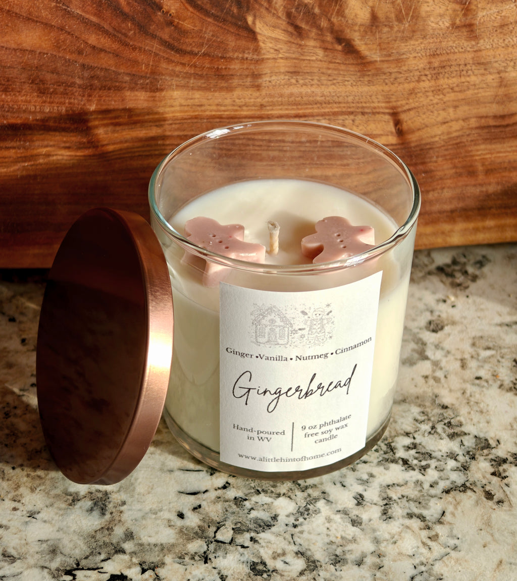 Gingebread soy wax candle with 2 gingerbread wax embeds on top. clear jar with copper lid