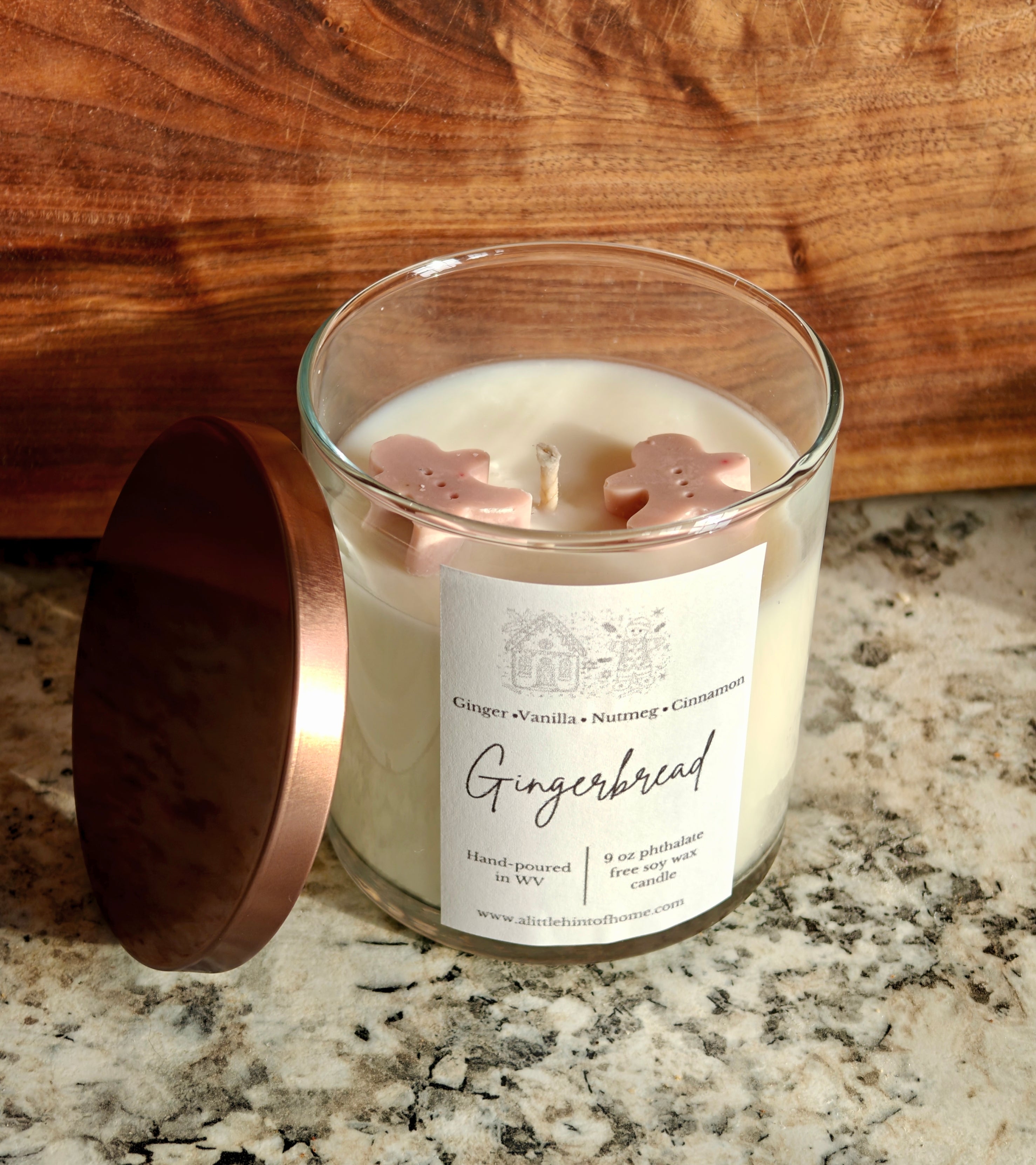 Gingebread soy wax candle with 2 gingerbread wax embeds on top. clear jar with copper lid