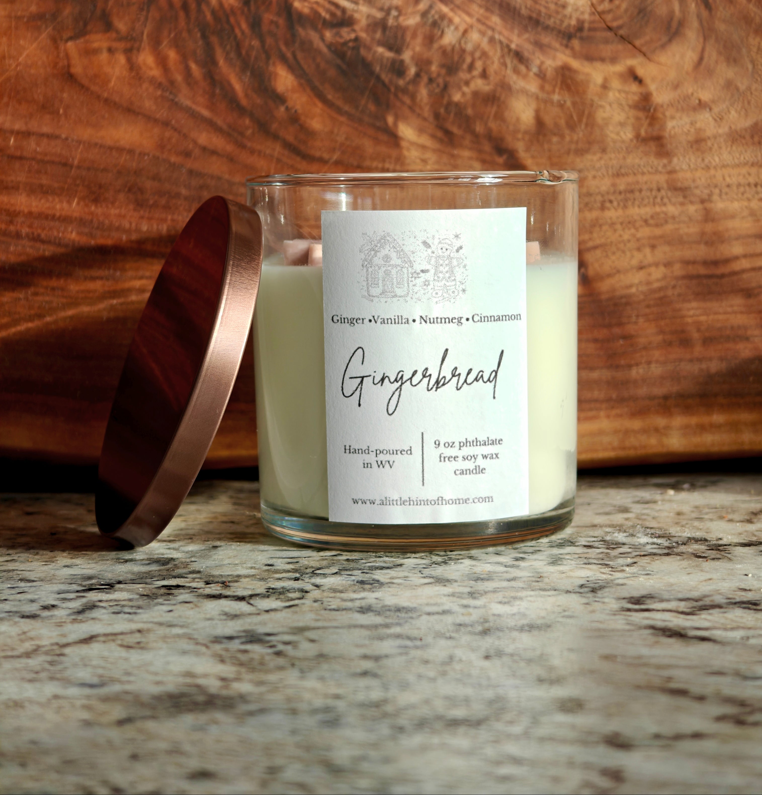 Gingebread soy wax candle with 2 gingerbread wax embeds on top. clear jar with copper lid