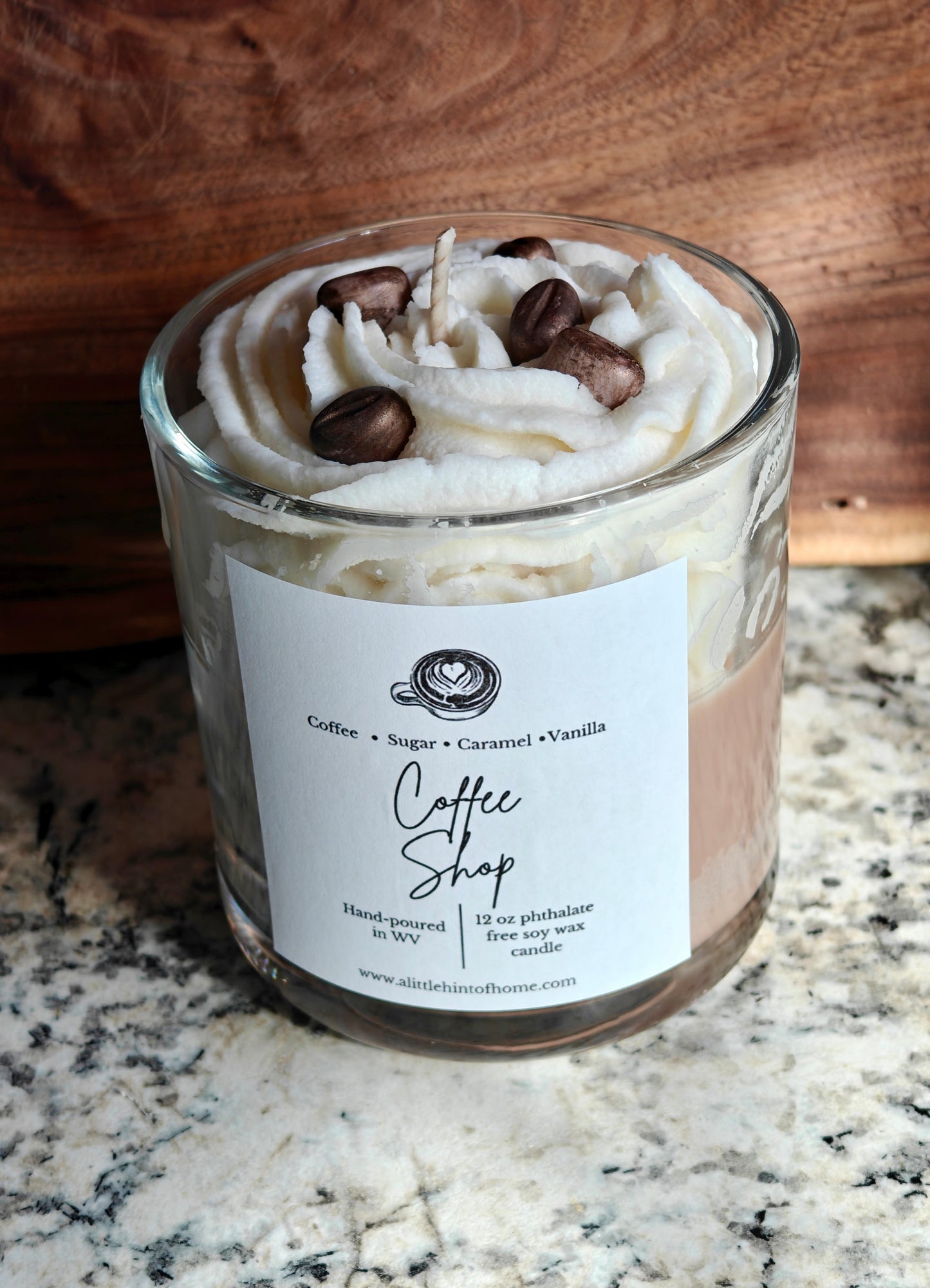 Candle in a glass jar with whipped wax and decorative coffee bean wax embeds on top, labeled 'Coffee Shop', on a marble surface.