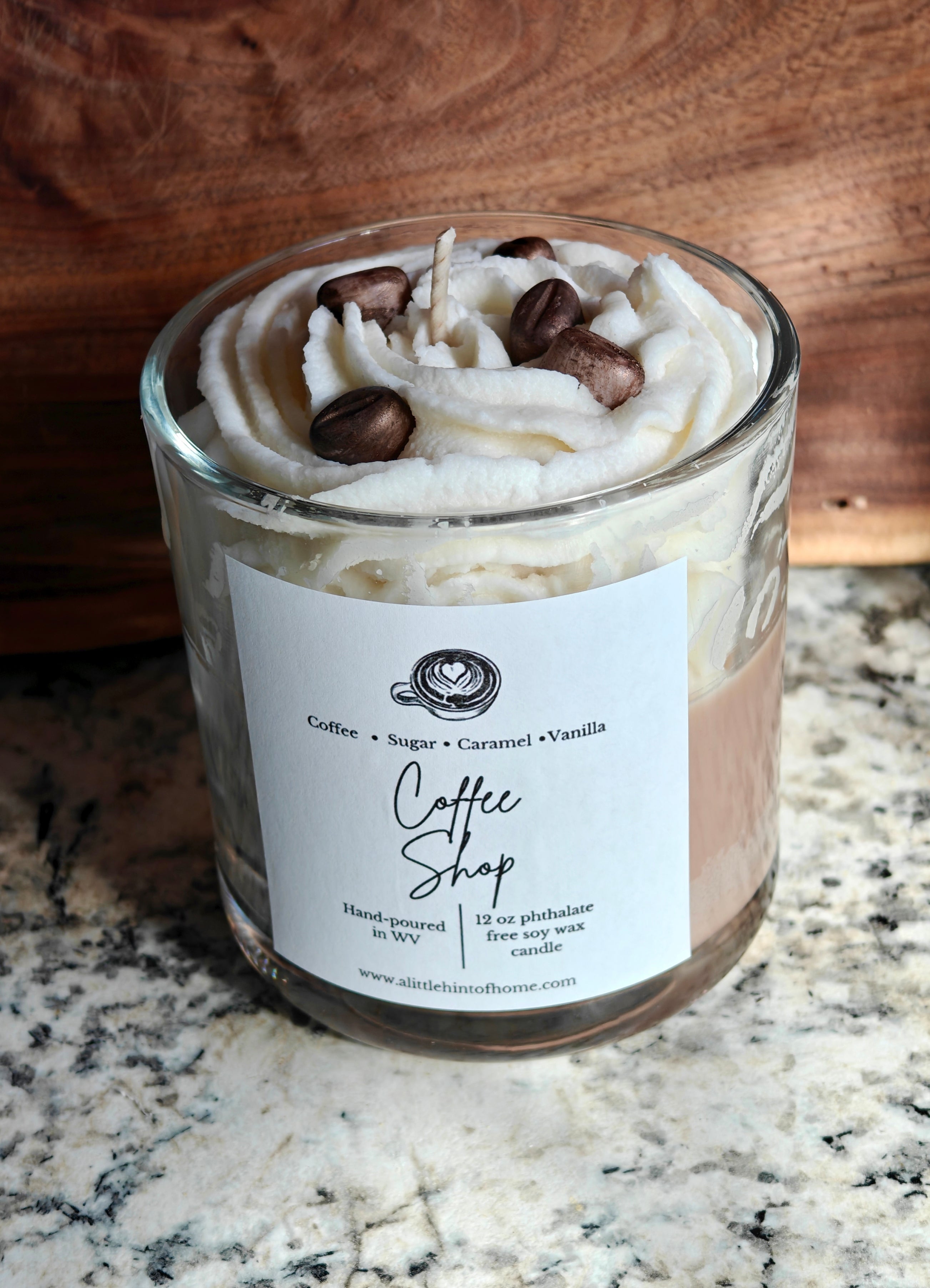 Candle in a glass jar with whipped wax and decorative coffee bean wax embeds on top, labeled 'Coffee Shop', on a marble surface.