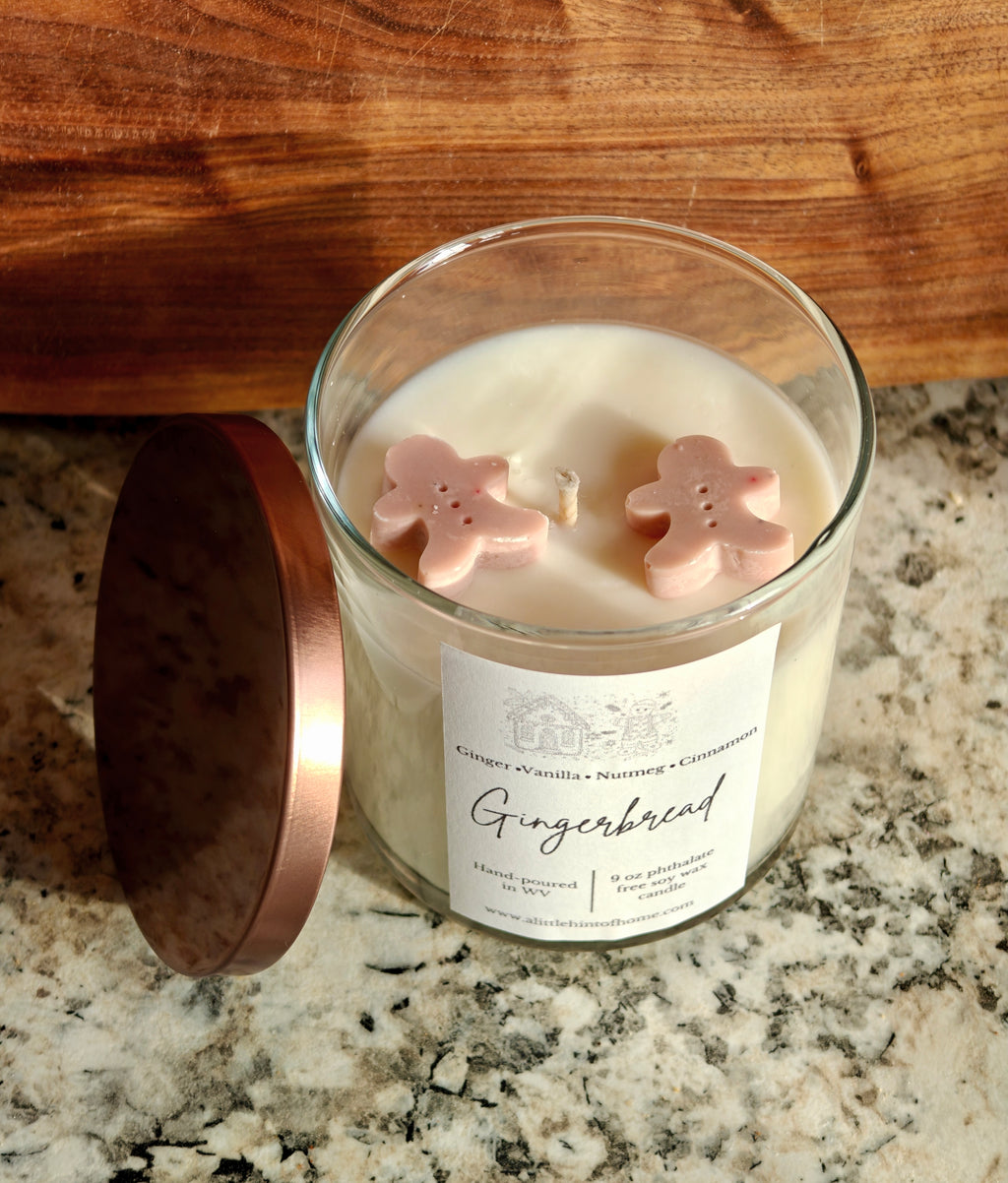 Gingebread soy wax candle with 2 gingerbread wax embeds on top. clear jar with copper lid