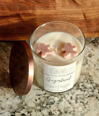 Gingebread soy wax candle with 2 gingerbread wax embeds on top. clear jar with copper lid