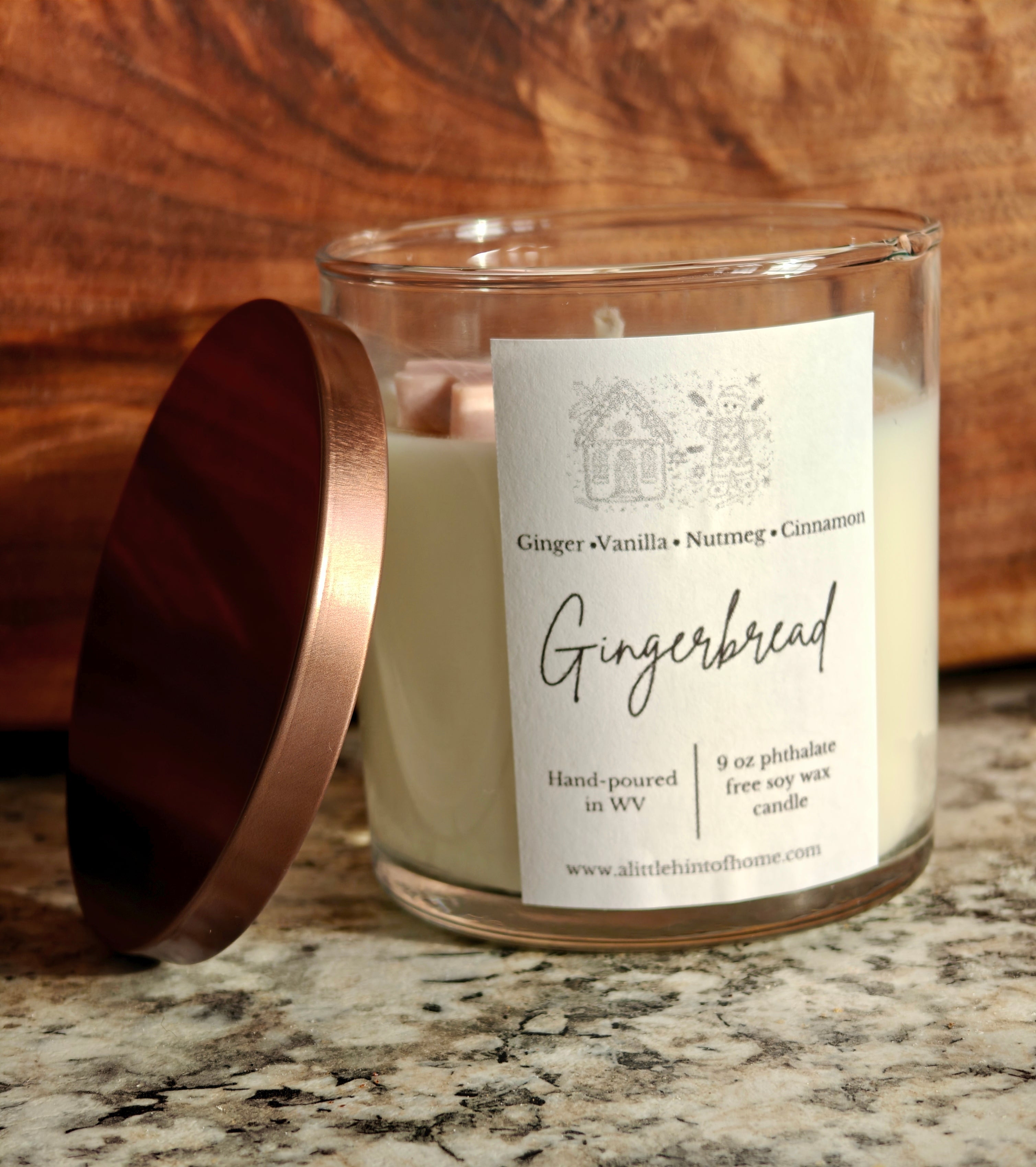 Gingebread soy wax candle with 2 gingerbread wax embeds on top. clear jar with copper lid