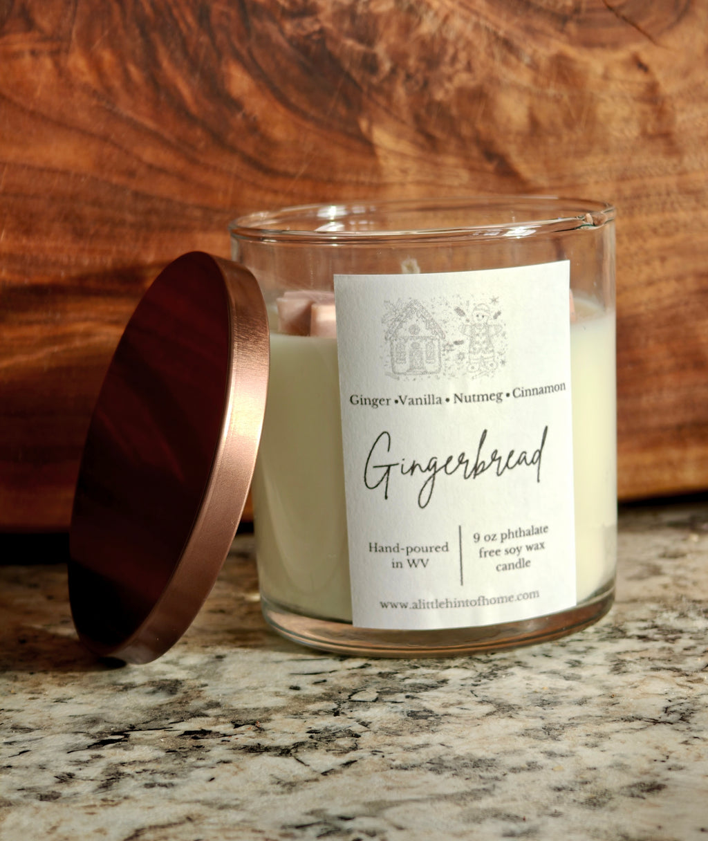 Gingebread soy wax candle with 2 gingerbread wax embeds on top. clear jar with copper lid